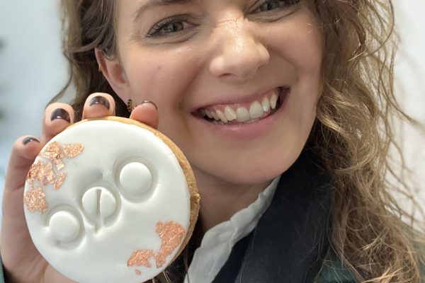 Ilana with an OQC branded cookie