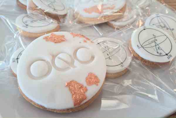 Quantum qubit cookies, made by the OQC team. They are covered in white icing and have the OQC logo on the front.