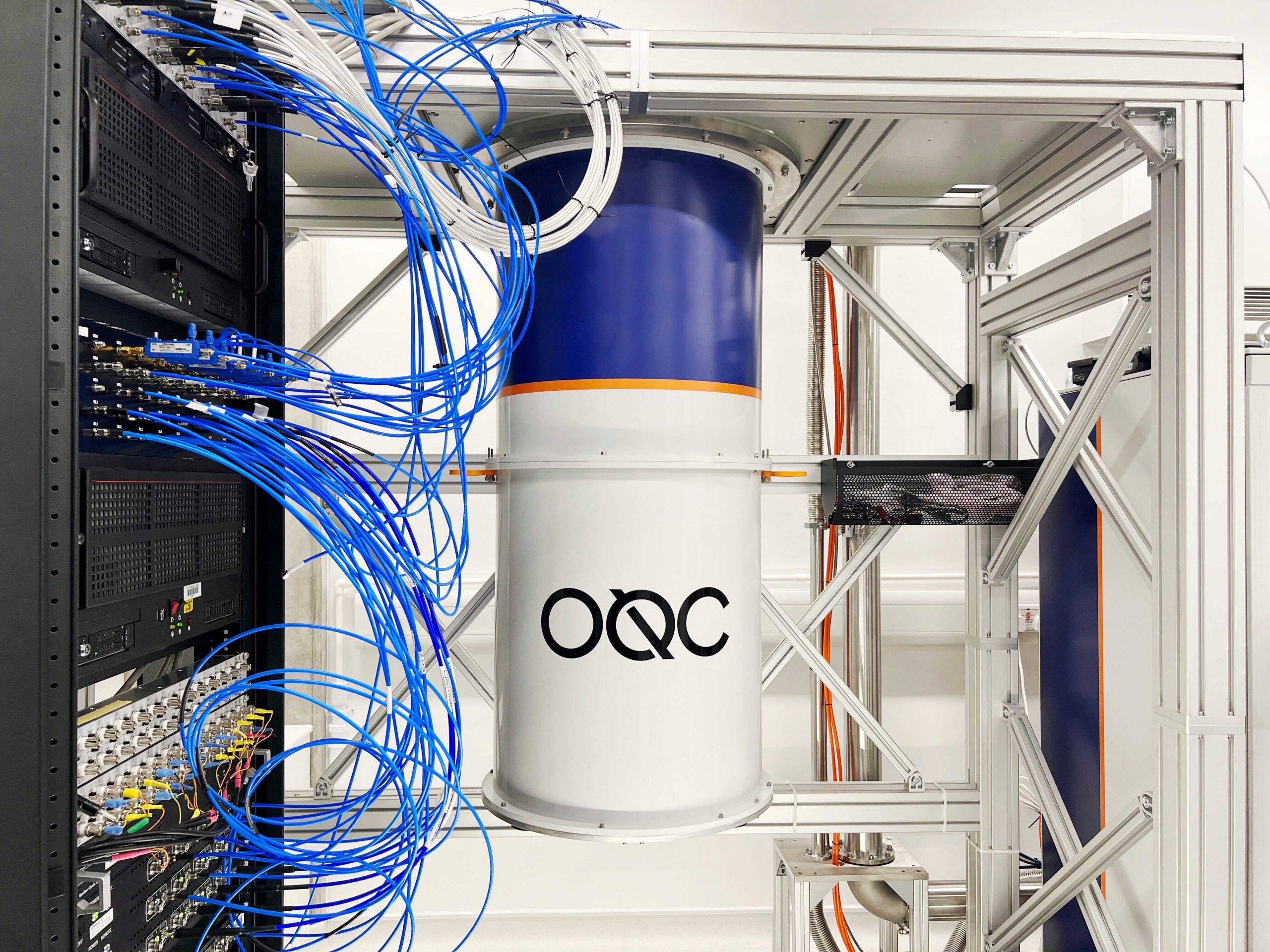 Picture of a quantum computer, with casing on. the logo OQC is on the front cans.