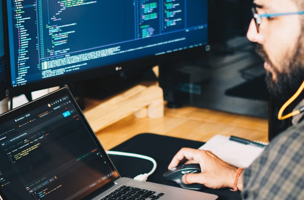 Person at laptop looking a screen filled with code
