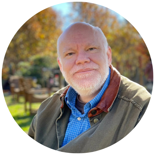 Picture of Todd Tilma, sitting in a park in the fall.