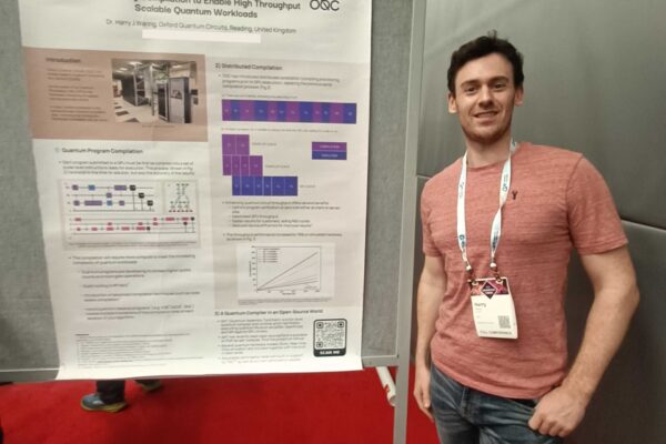 Harry standing in front of his poster at IEEE